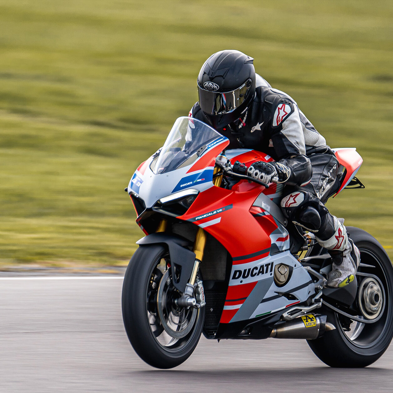 one motorbike racer on a ducati motorbike going along a straight stretch of track